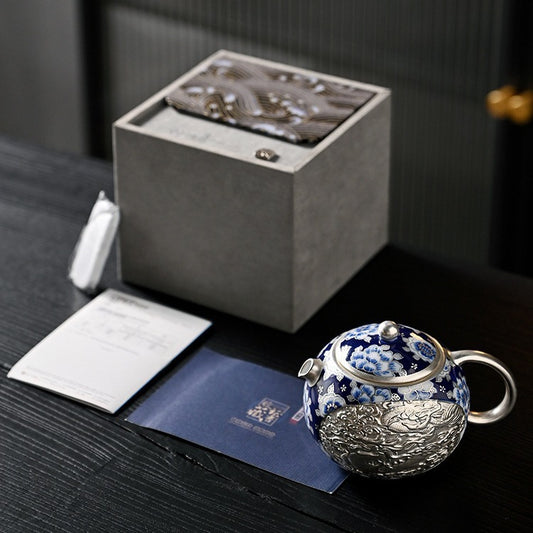 Handcrafted silver "Xishi" style teapot featuring dragon and phoenix relief, blue-and-white accents, and silver gilding; a premium Gongfu tea vessel for home use.