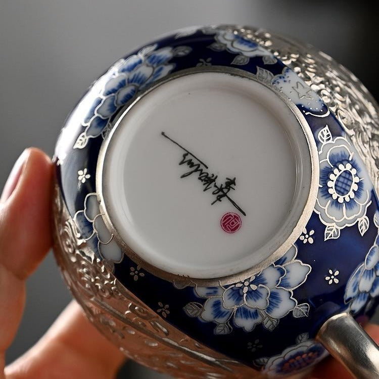 Handcrafted silver "Xishi" style teapot featuring dragon and phoenix relief, blue-and-white accents, and silver gilding; a premium Gongfu tea vessel for home use.
